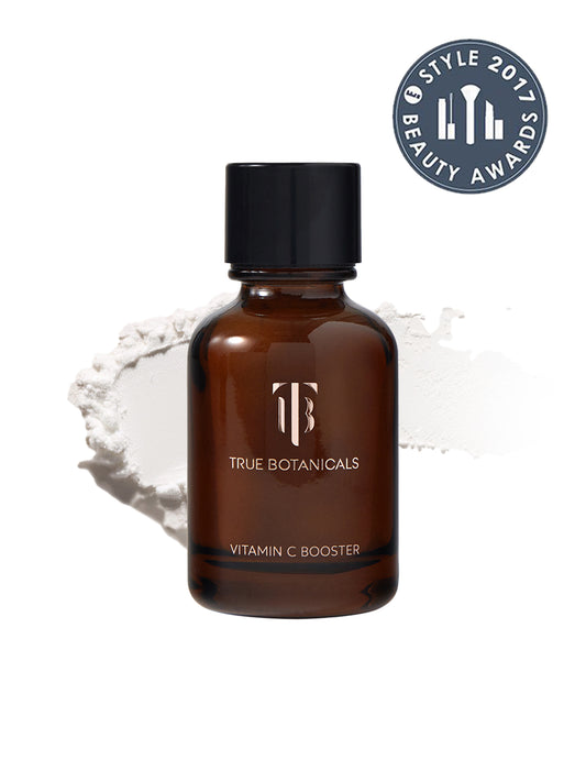 This image highlights the True Botanicals Vitamin C Booster, a skincare product designed to brighten and even skin tone while addressing dark spots. The product is displayed alongside its powdered form, indicating its fresh, potent formulation that activates when mixed with water or serum. The 2017 Style Beauty Award badge is prominently displayed, reinforcing its recognition for effectiveness and clean ingredients.