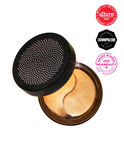 Open container of eye patches with decorative lid, featuring awards on a white background