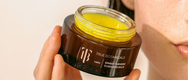 Model holding Ginger Turmeric Cleansing Balm up close.