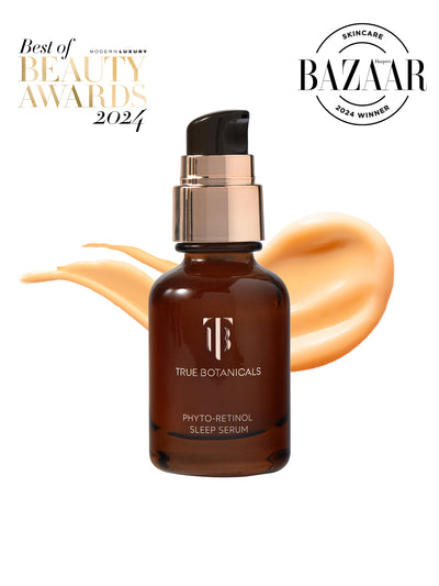 A bottle of True Botanicals Phyto-Retinol Sleep Serum in a dark amber glass container with a pump dispenser is displayed against a white background. Smooth swirls of golden serum are spread behind the bottle. Award badges for "Modern Luxury Best of Beauty Awards 2024" and "Harper's Bazaar Skincare 2024 Winner" are featured in the top corners.