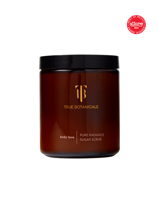 Brown jar of Pure Radiance Sugar Exfoliating Body Scrub from True Botanicals with black lid on a white background