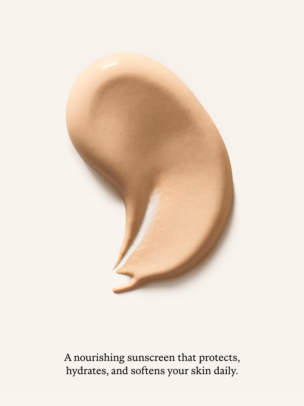 A swatch of beige-tan sunscreen cream on a light cream background, with small black text below reading, 'A nourishing sunscreen that protects, hydrates, and softens your skin daily.'.